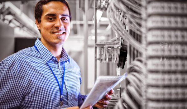 Portrait of technician analyzing server in server room